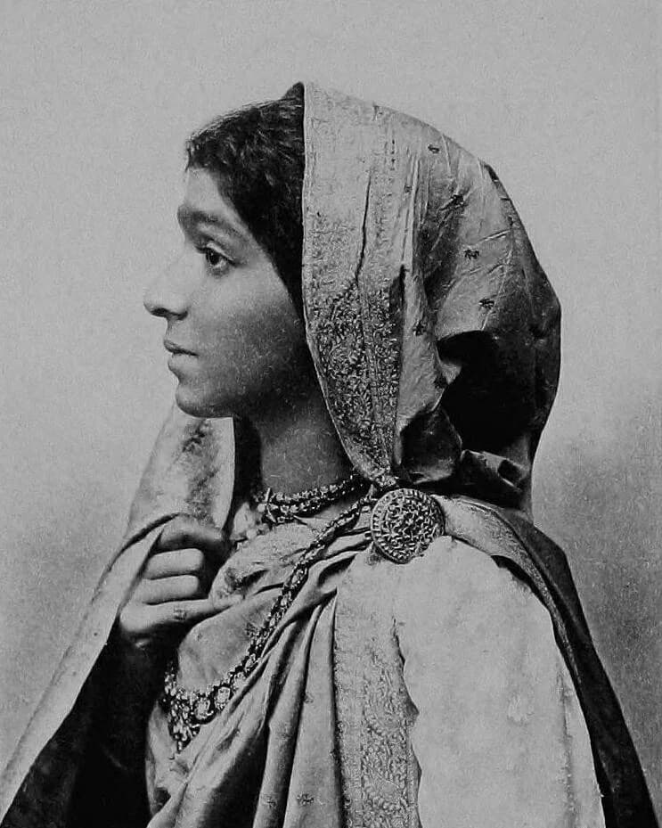 Sarojini Naidu in profile, wearing a sari draped over her head