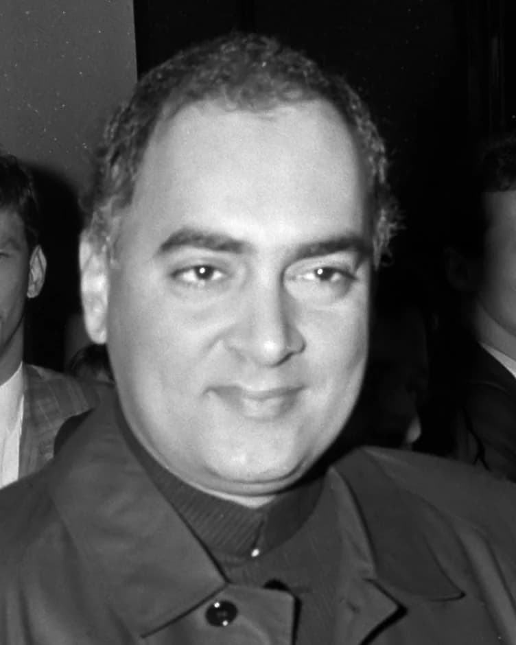 Rajiv Gandhi smiling, in a dark high-collared jacket